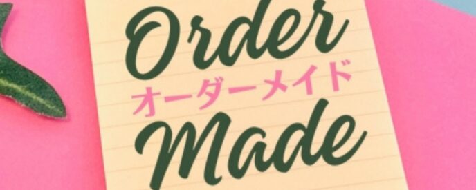 ピンクの背景に『Order Made(オーダーメイド)』と書かれたメモと観葉植物の葉