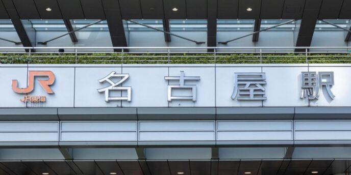 JR名古屋駅の駅名サインと現代的な駅舎外観のクローズアップ