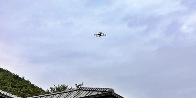 戸建て住宅の屋根上空を飛行する小型ドローン