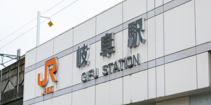 JR岐阜駅の駅名標が写る、鉄道高架と看板のクローズアップ。