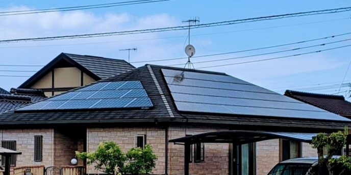 住宅の屋根に設置された太陽光パネル、家庭用再生可能エネルギーの導入例