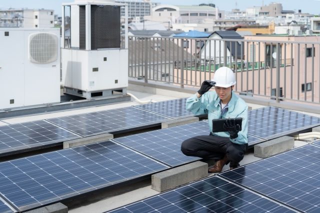 太陽光パネルのメンテナンスをする男性