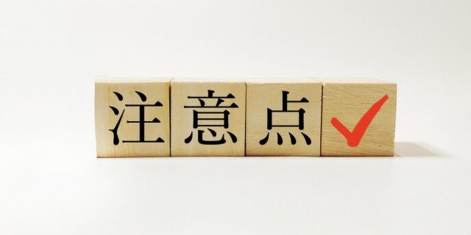 注意点と書かれた木のブロックと赤いチェックマーク、重要事項を示すイメージ