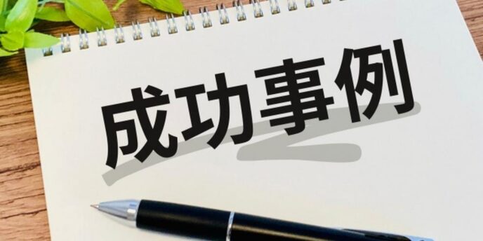 成功事例』と書かれたノートと黒いボールペンが置かれたデスクのイメージ