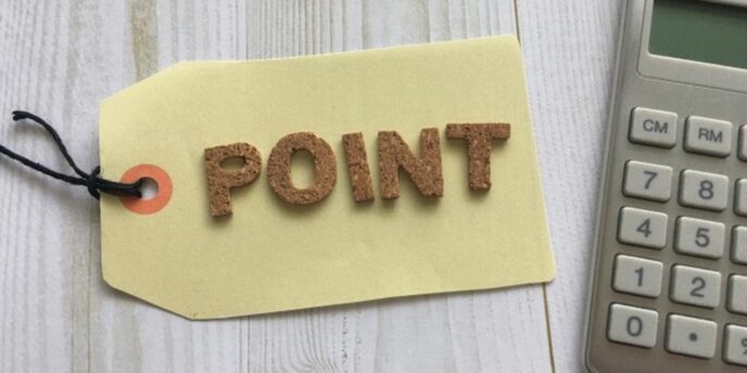 『POINT』と書かれたタグと電卓が並ぶ木目調のデスク上のイメージ