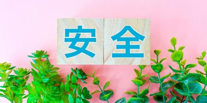 ピンクの背景に『安全』と書かれた木のブロックと観葉植物が並ぶイメージ