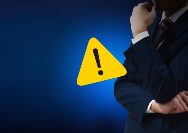 ビックリマークと腕を組む男性