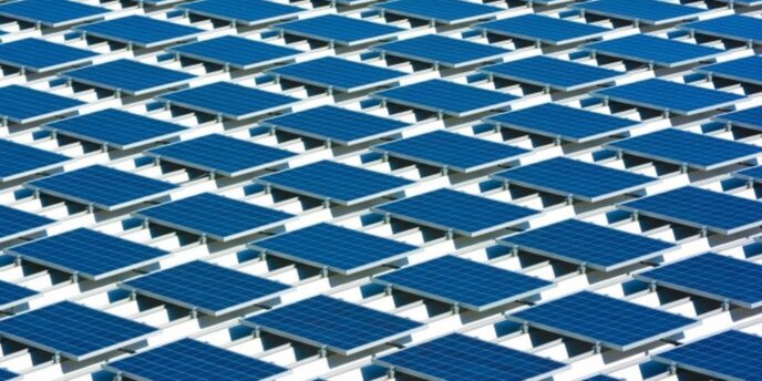 規則的に並んだ大量の太陽光パネルが設置された屋根の風景
