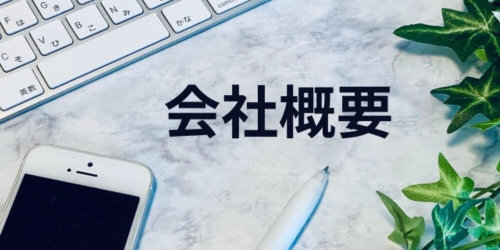 キーボードとスマホの間に表示された会社概要の文字