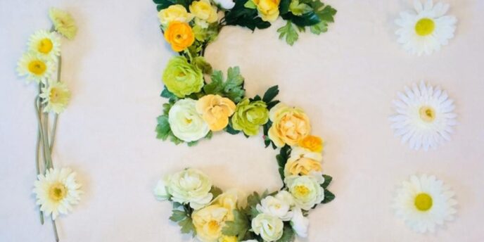 黄色と白の花で装飾された「5」の文字が中央に配置された華やかな壁面装飾。