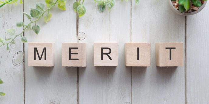 木製ブロックに並べられた「MERIT」の文字と観葉植物の装飾