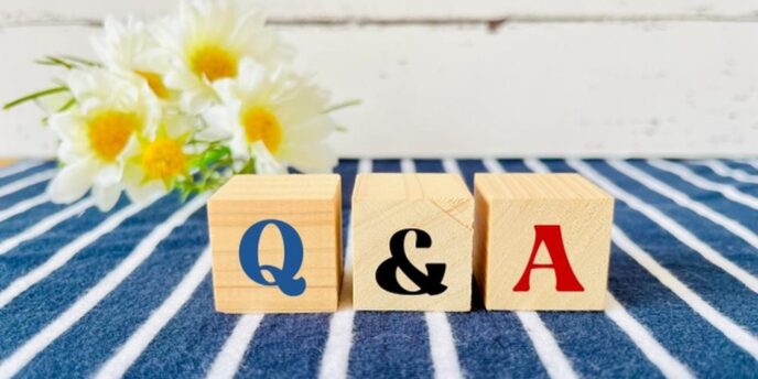 花とストライプのクロスの上に置かれた木製ブロックに「Q & A」の文字。
