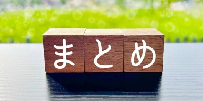 まとめと書かれた木のブロックと緑が広がる背景、記事の締めや要点整理のイメージ