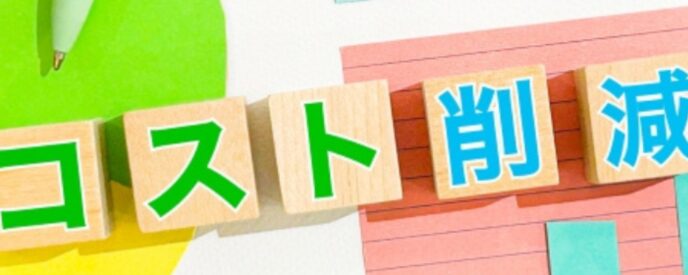 カラフルな背景に木製ブロックで「コスト削減」と書かれたイメージ。コスト最適化や経費節減を示すビジネス向けの視覚素材。