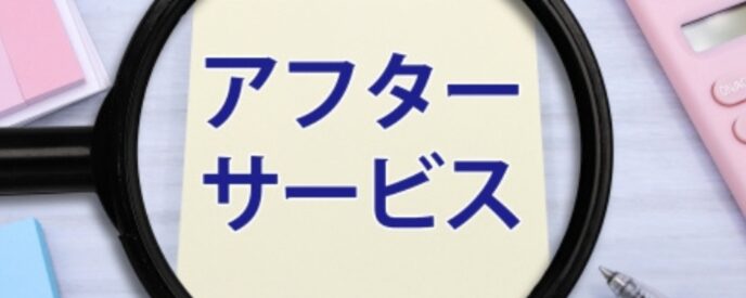 付箋に『アフターサービス』と書かれた画像、虫眼鏡と電卓が見える