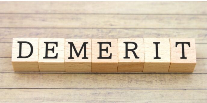「DEMERIT」と書かれた木製ブロック、デメリットの強調イメージ