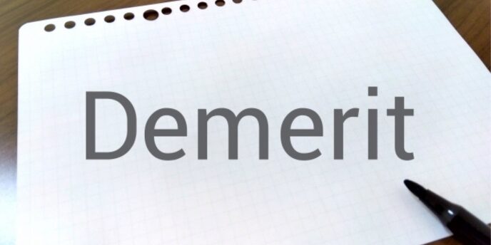方眼紙に「Demerit」と書かれた文字と黒ペンのあるシンプルなイメージ
