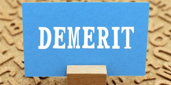 コルクボードの上に立てられた「DEMERIT(デメリット)」の青いカード
