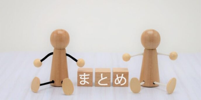 『まとめ』と書かれた木のブロックと両側に座る木製の人形