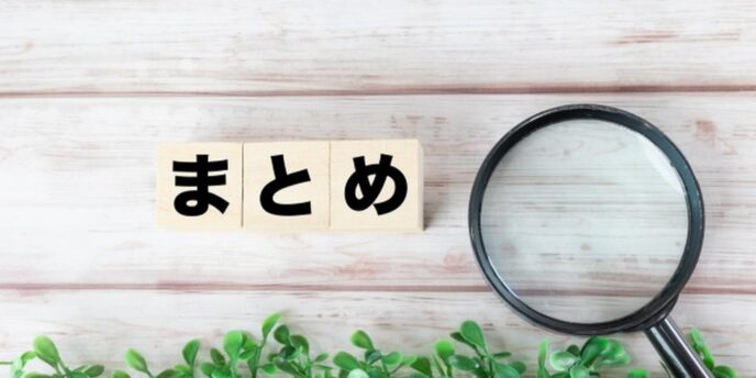 木目の背景に『まとめ』と書かれたブロックと虫眼鏡が置かれている写真