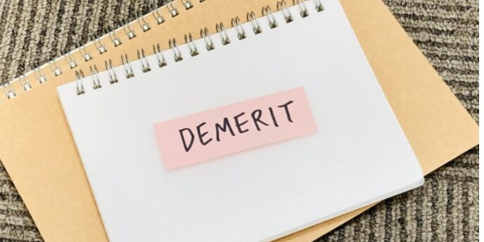 ノートの上に貼られた「DEMERIT」のラベルイメージ