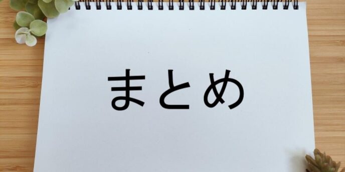 白いスケッチブックに「まとめ」と書かれた画像、木製の背景と観葉植物でナチュラルな印象