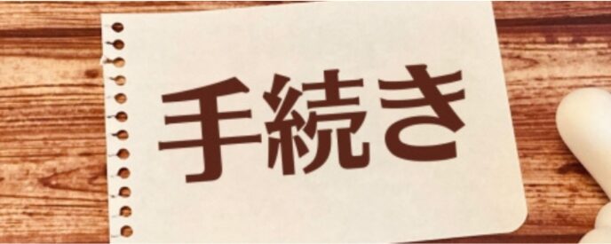 手続きと書かれた紙と指差しマーク、申請や手順をイメージした写真