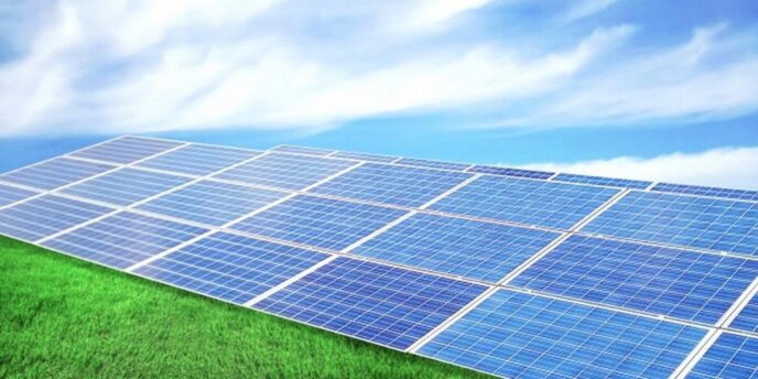 草原に設置された広大な太陽光パネルと青空、クリーンエネルギーのイメージ